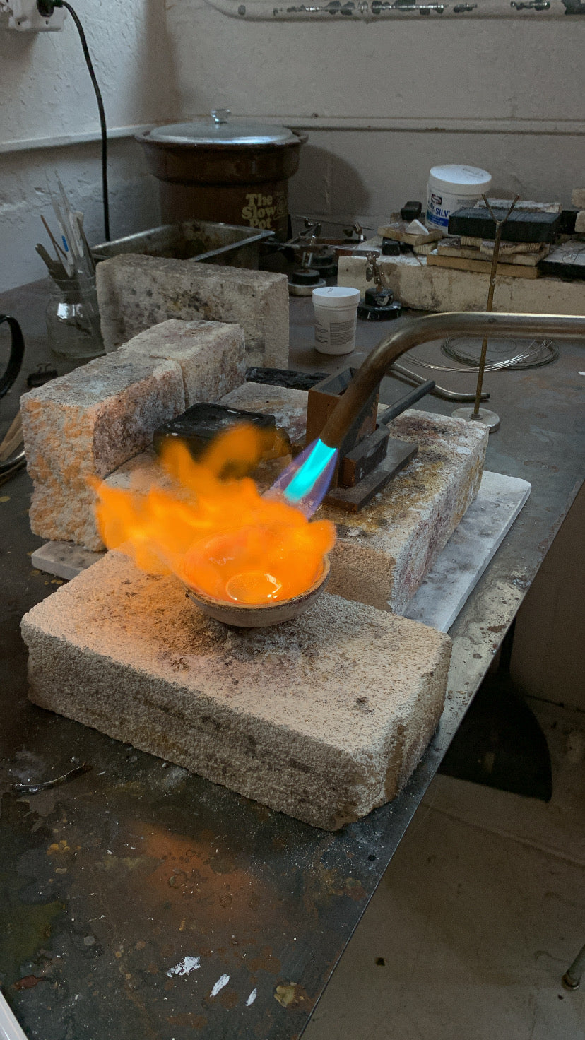melting silver in a crucible using a torch