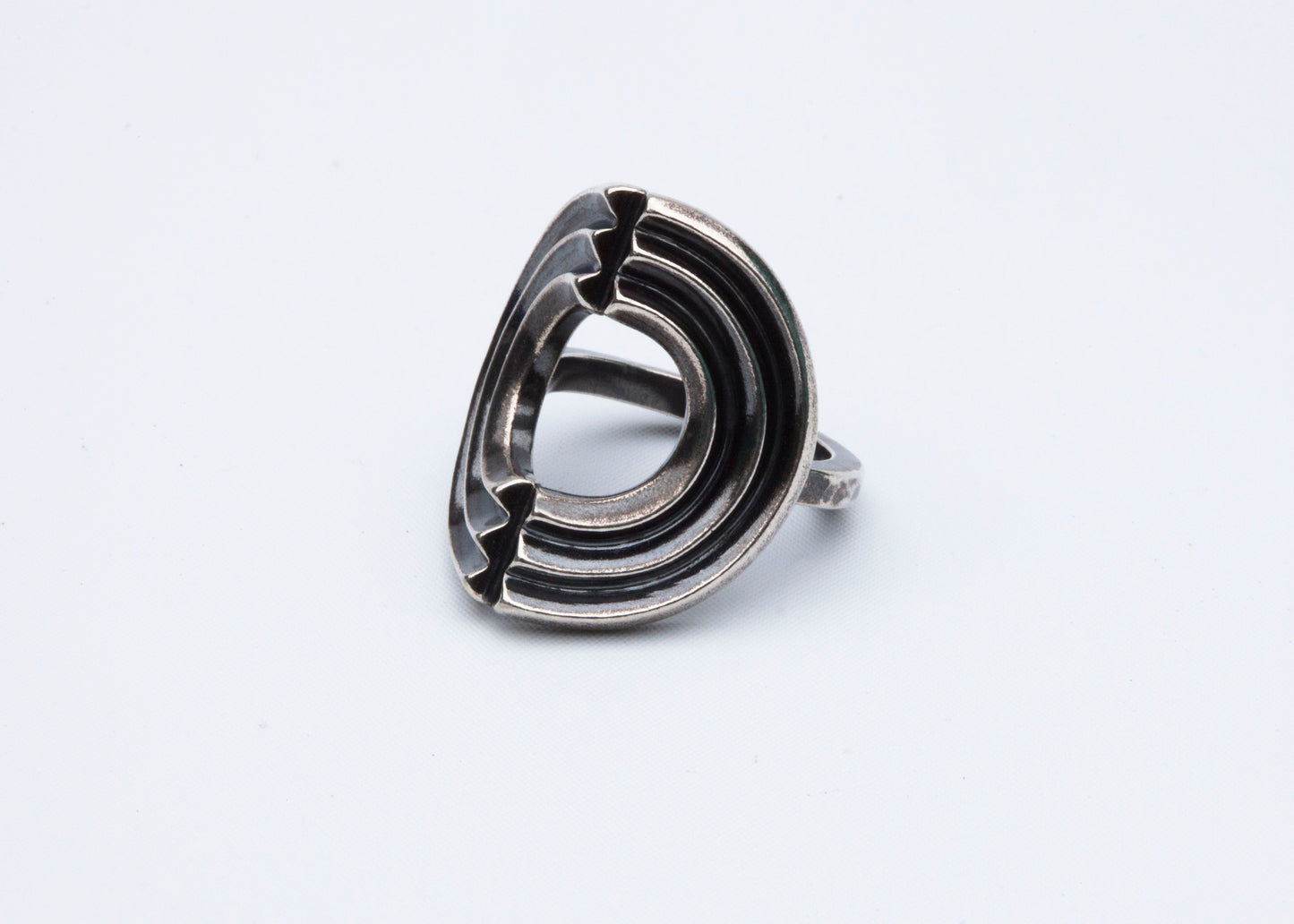 Echo Metals Triple Shield band ring featuring three interconnected shield-shaped designs on a sleek metal band.