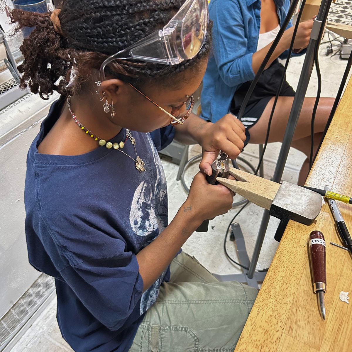 Close-up of a jewelry class brochure cover featuring the title "Intro to Jewelry" by Alloy Atelier with jewelry design images.