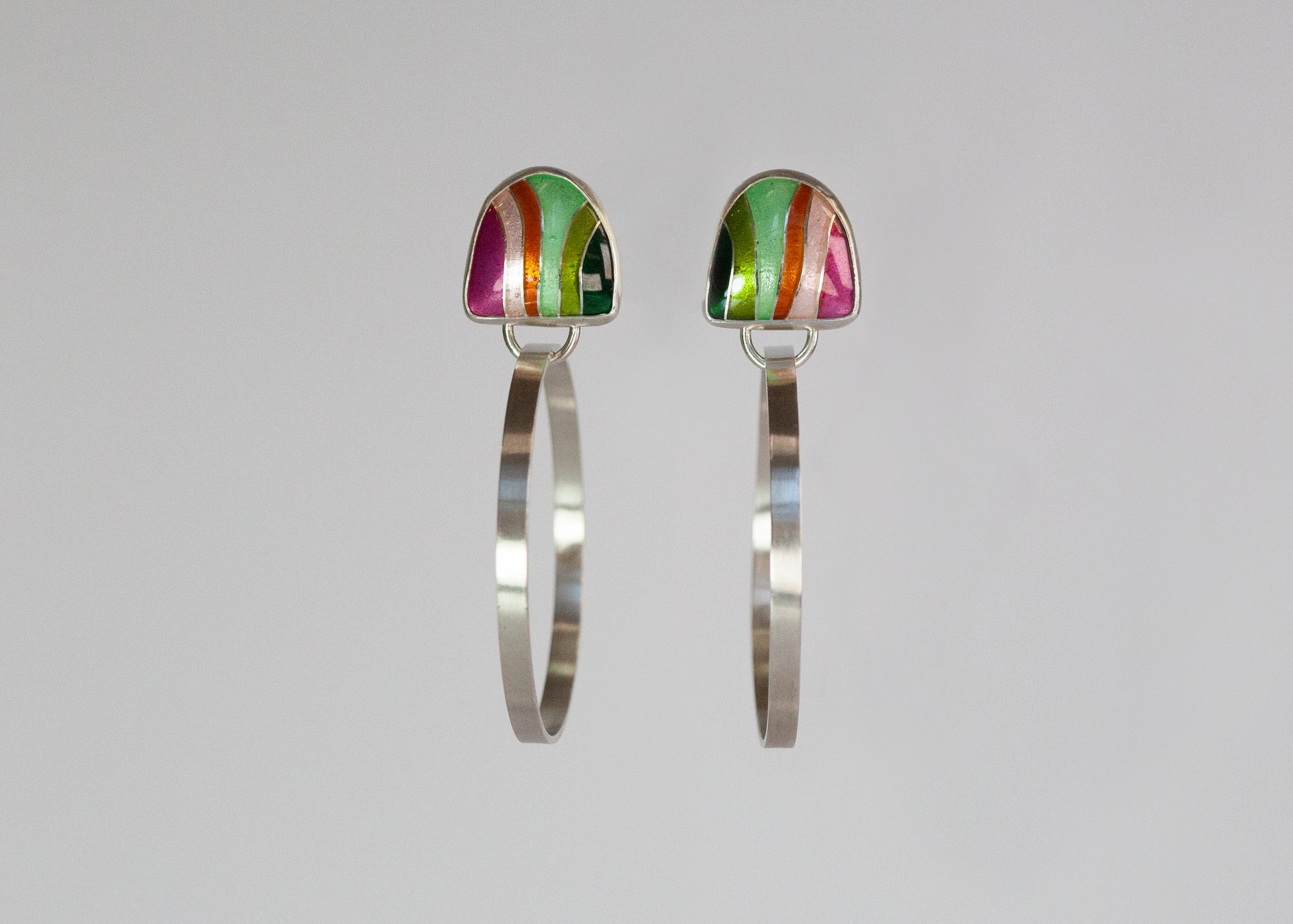 Pink and green flat metal hoops from Echo Metals, stylish Loopy Hoops jewelry with a modern design.