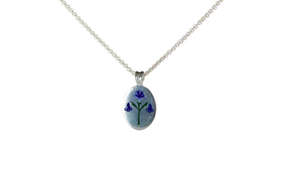 Ellyse Bendillo painted house lily pendant necklace with blue enamel flower, showcasing intricate floral design on a delicate chain.