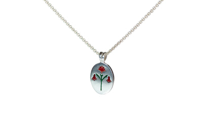 Red enamel Painted House Lily pendant necklace by Ellyse Bendillo featuring a delicate flower design on a chain.