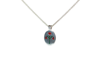Ellyse Bendillo painted house lily pendant necklace with a vibrant red enamel flower design on a chain.