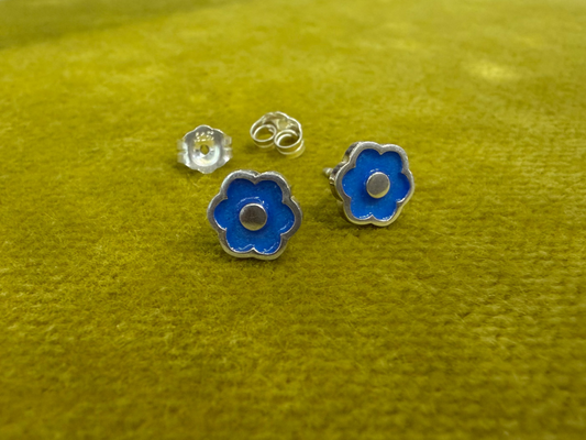 Small flower-shaped studs by Ellyse Bendillo, delicate silver earrings featuring intricate floral designs.