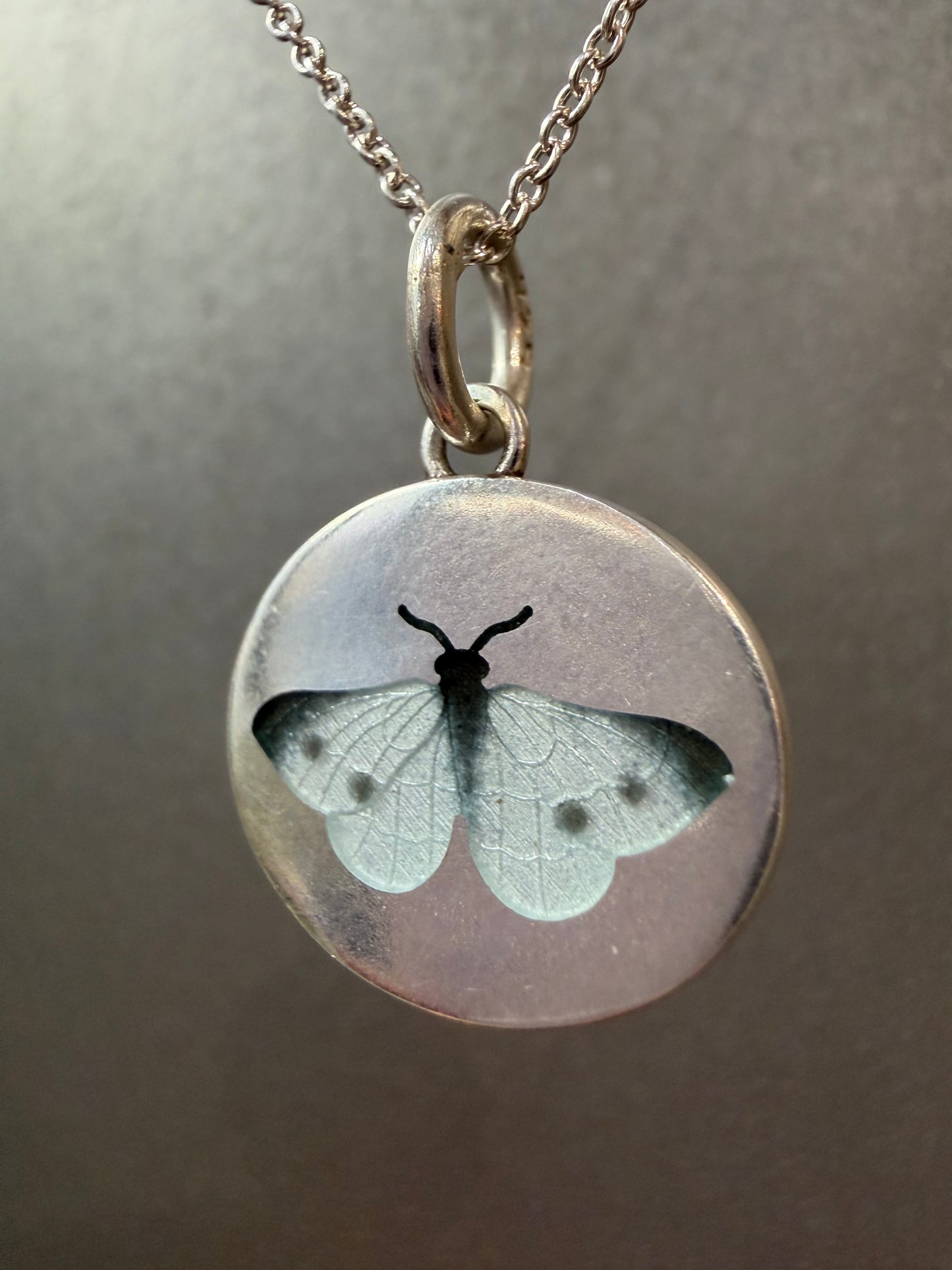 White butterfly charm from Ellyse Bendillo, close-up view showing intricate details and delicate design.