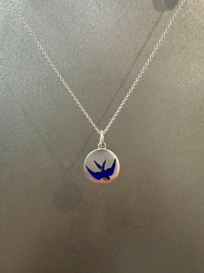 Ellyse Bendillo swallow charm, delicate silver jewelry piece with intricate bird design, close-up view of the charm's details