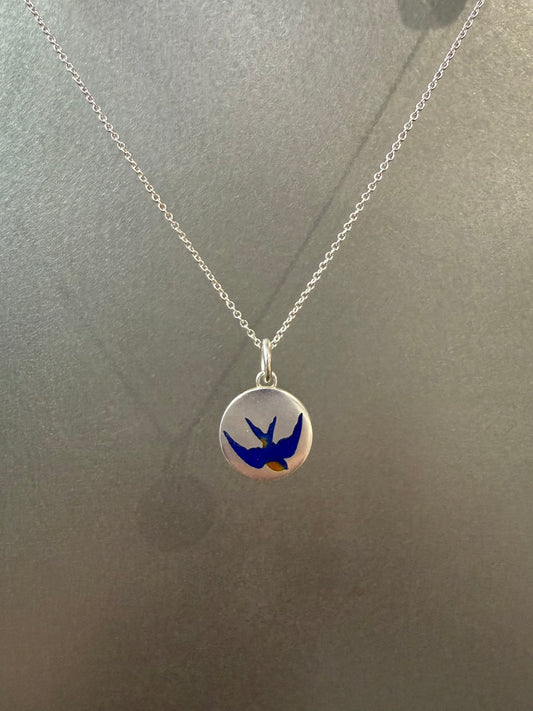 Ellyse Bendillo swallow charm, delicate silver jewelry piece with intricate bird design, close-up view of the charm's details