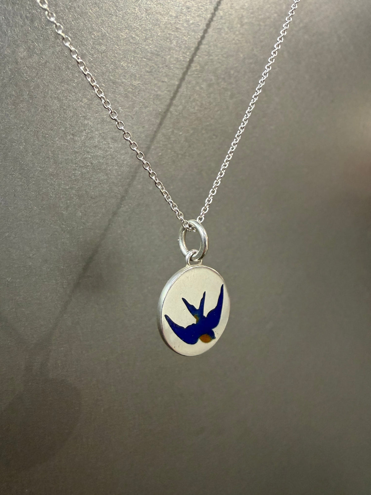 Ellyse Bendillo swallow charm, delicate metal jewelry charm with intricate bird design for bracelets or necklaces.