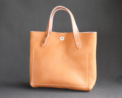 Spartan Made leather mini tote bag with natural leather finish, showing the back view with clean stitching and compact design