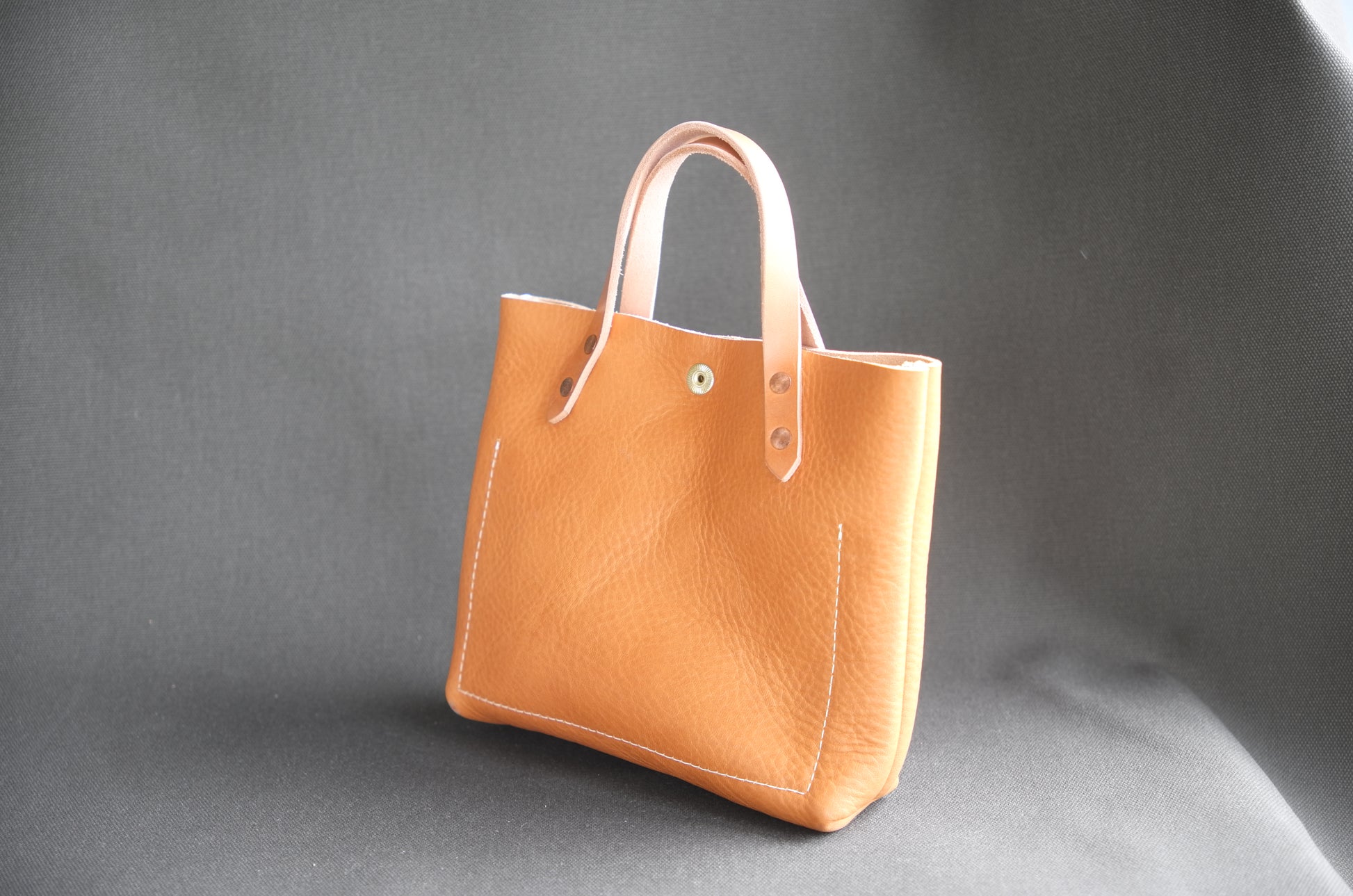 Natural leather mini tote bag by Spartan Made showing the back view with a smooth finish and compact design.