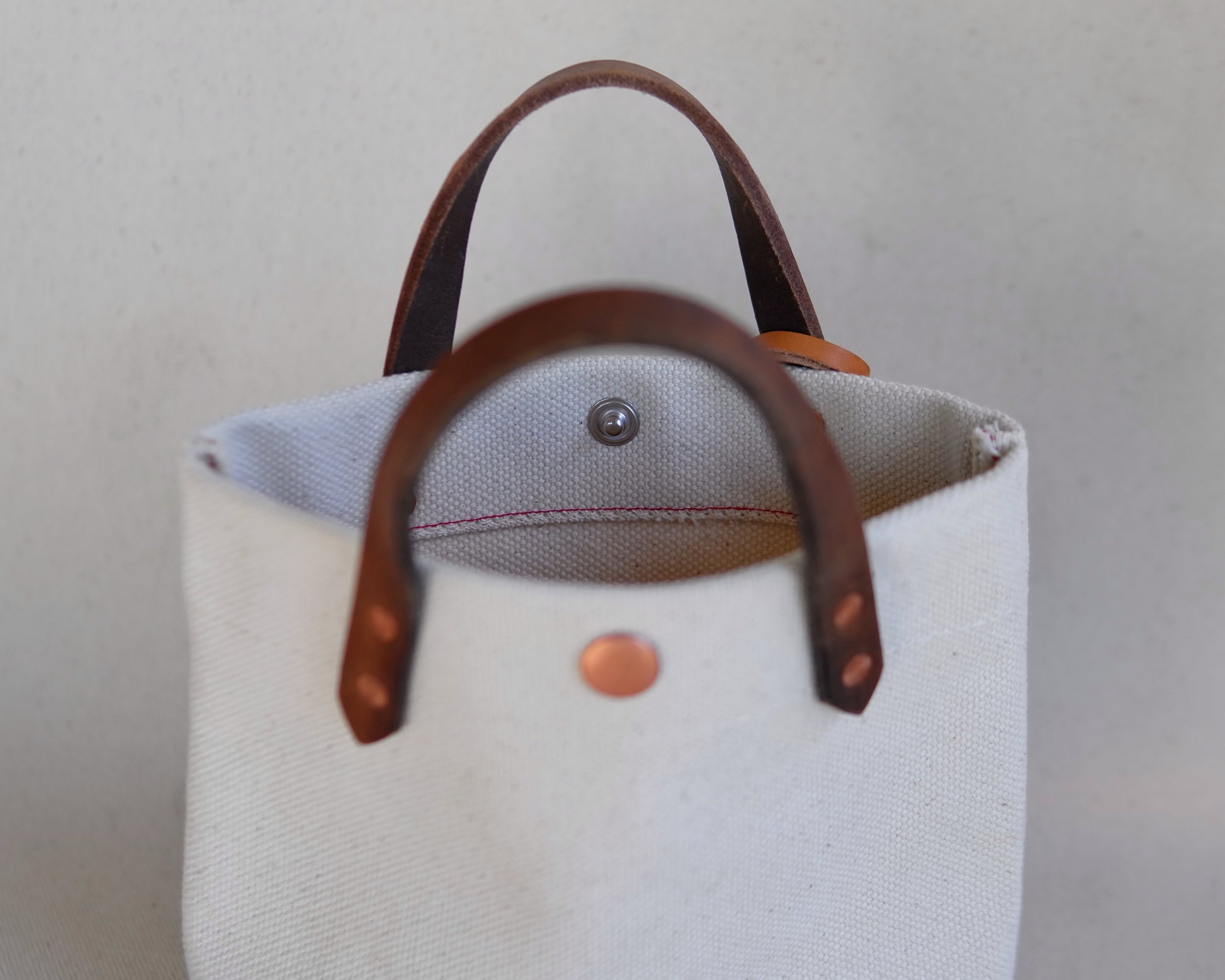 Close-up of Spartan Made mini canvas tote bag showing textured fabric, sturdy handles, and minimalist design details.