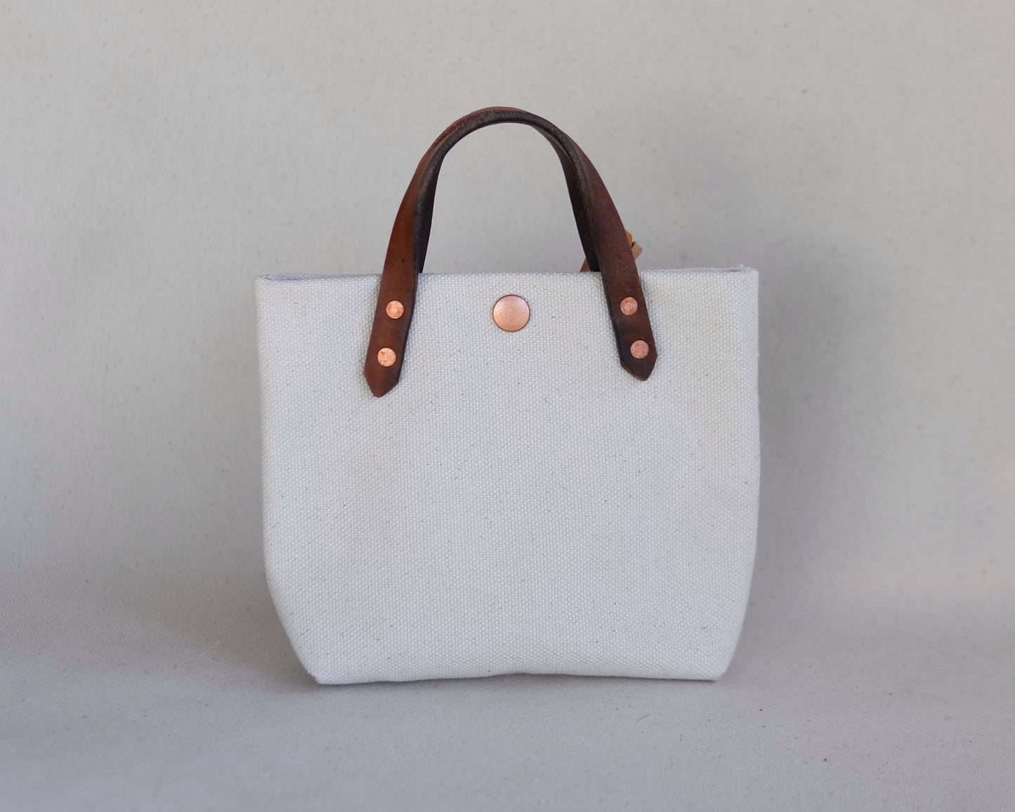 Spartan Made mini tote bag in canvas with front view, showcasing its compact design and sturdy handles.