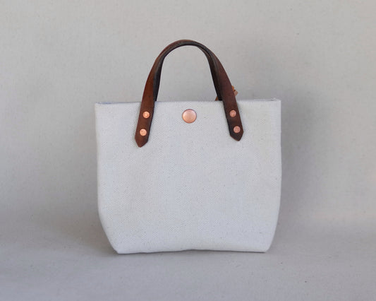 Spartan Made mini tote bag in canvas with front view, showcasing its compact design and sturdy handles.