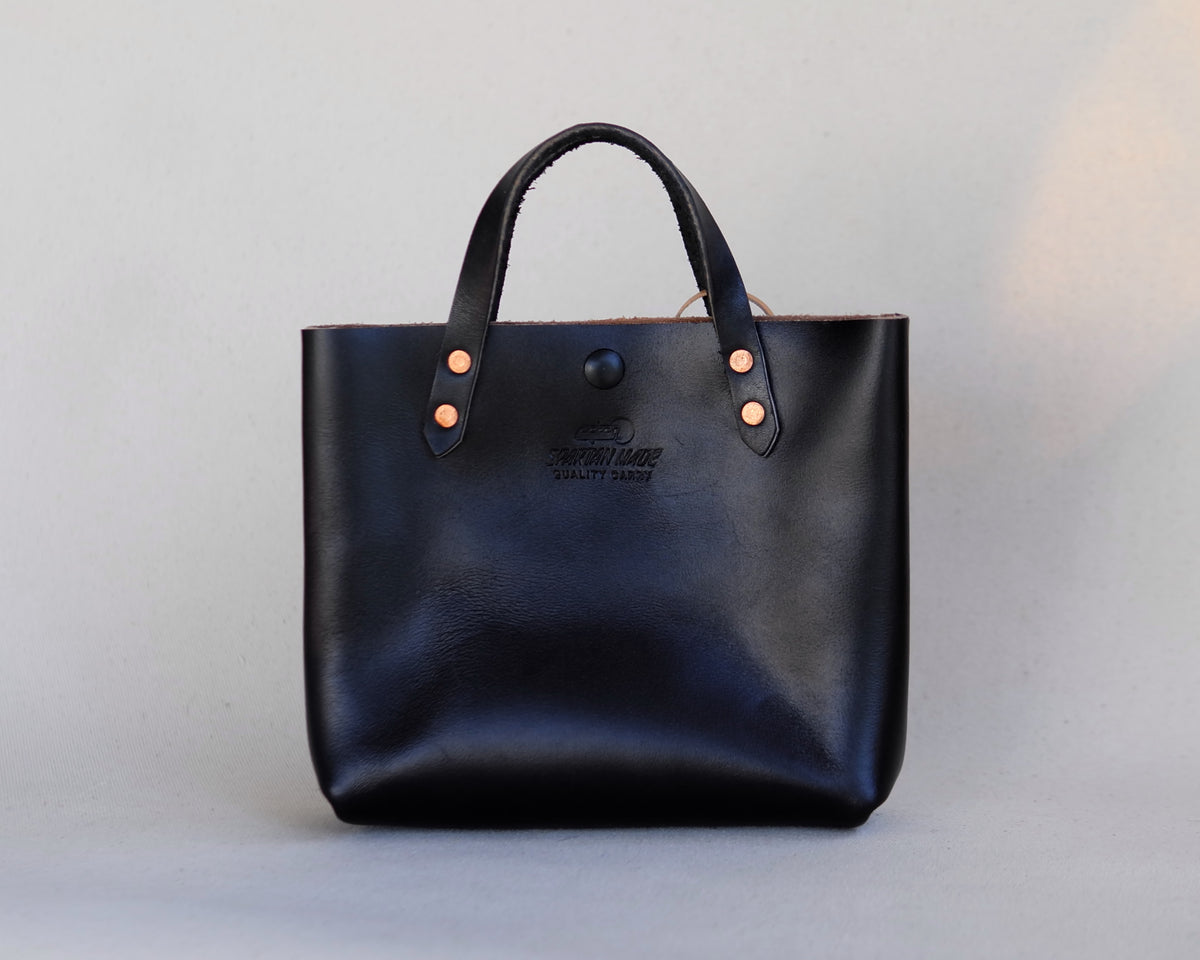 Black leather Mini Tote bag by Spartan Made, showing the front view with sleek design and sturdy handles.