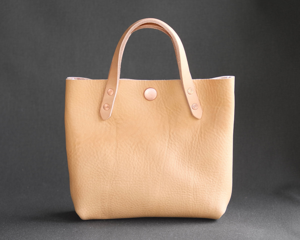Spartan Made mini leather tote bag with natural leather finish, front view showing sleek design and sturdy handles.