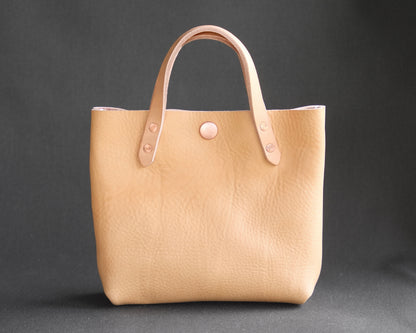 Spartan Made mini leather tote bag with natural leather finish, front view showing sleek design and sturdy handles.