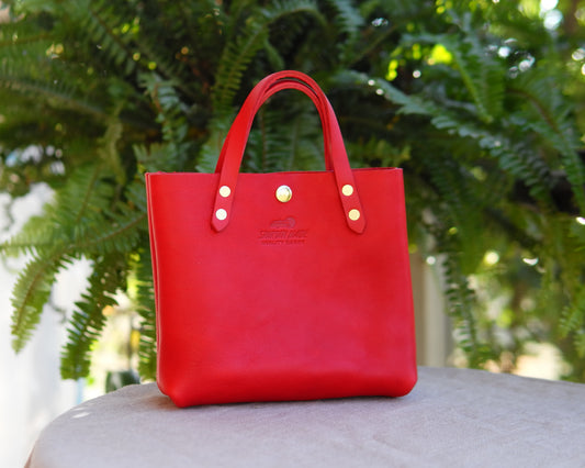 Red leather Spartan Made Mini Tote bag with front styled design and sturdy handles, perfect for everyday use.