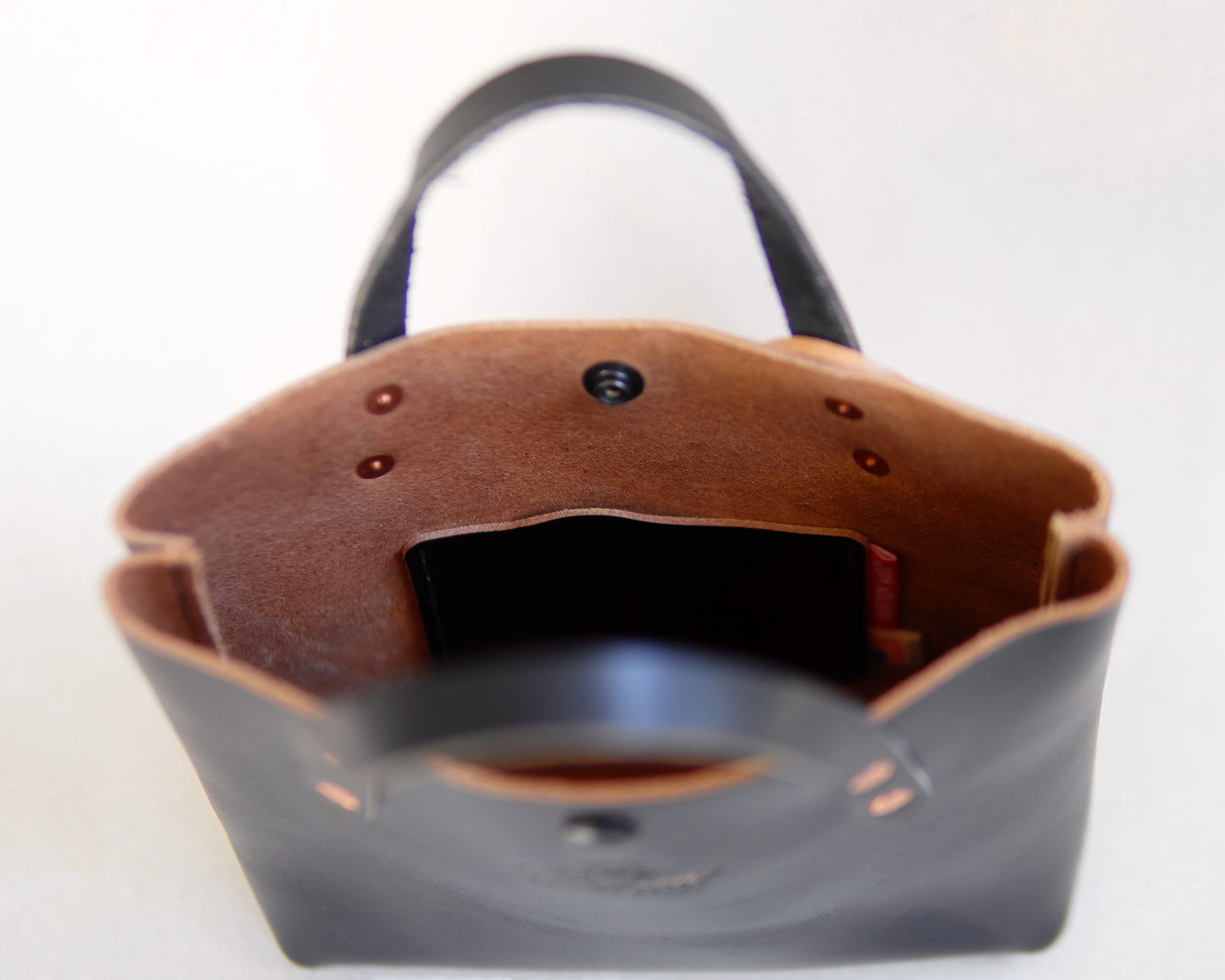 Black leather mini tote bag by Spartan Made, showing the spacious interior and sleek design for everyday use.