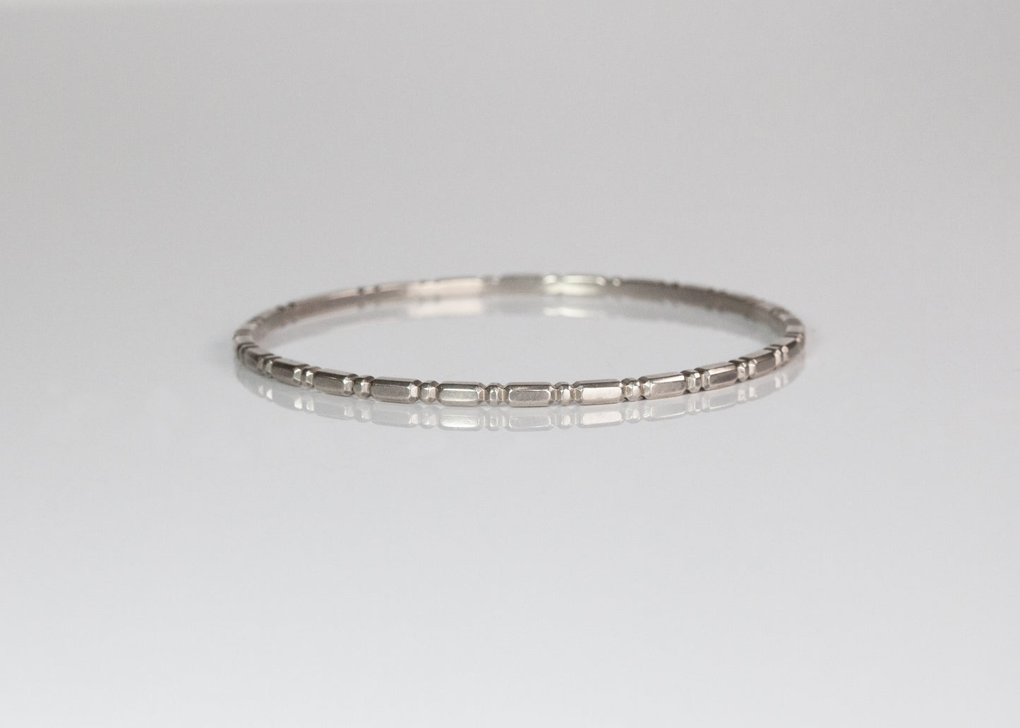 Silver Orbit Bangle by The Tiny Jeweler, sleek and minimalist jewelry accessory displayed flat on a neutral background.