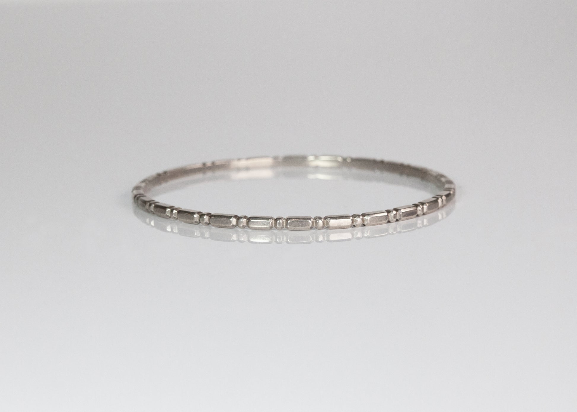Silver Orbit Bangle by The Tiny Jeweler, sleek and minimalist jewelry accessory displayed flat on a neutral background.