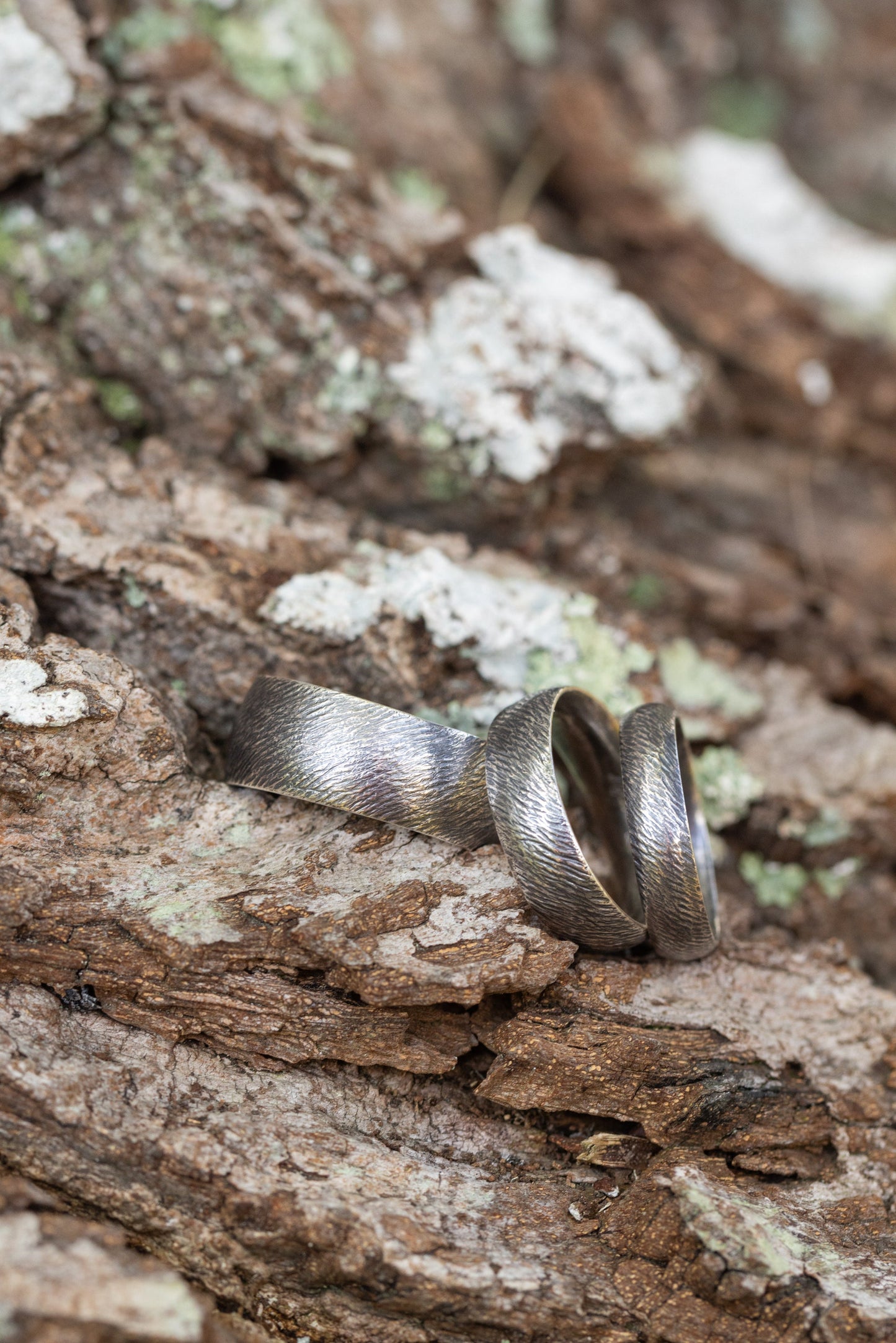 Textured band ring by The Tiny Jeweler, showcasing a close-up of the elegant, detailed design on a sleek metal band.