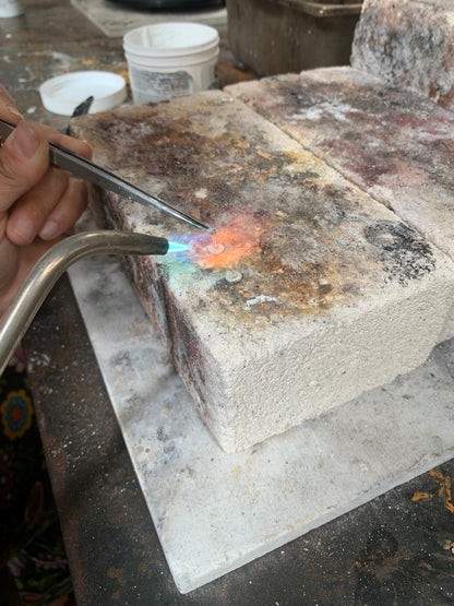 Close-up of alloy atelier post earrings being soldered during a jewelry workshop session