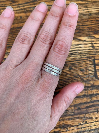 Set of Alloy Atelier stacking rings in various sizes and finishes, displayed together on a neutral background.