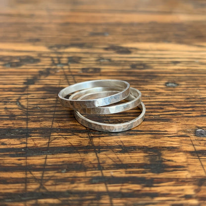 Set of Alloy Atelier stacking rings with mixed metals, simple and modern jewelry design on a white background.